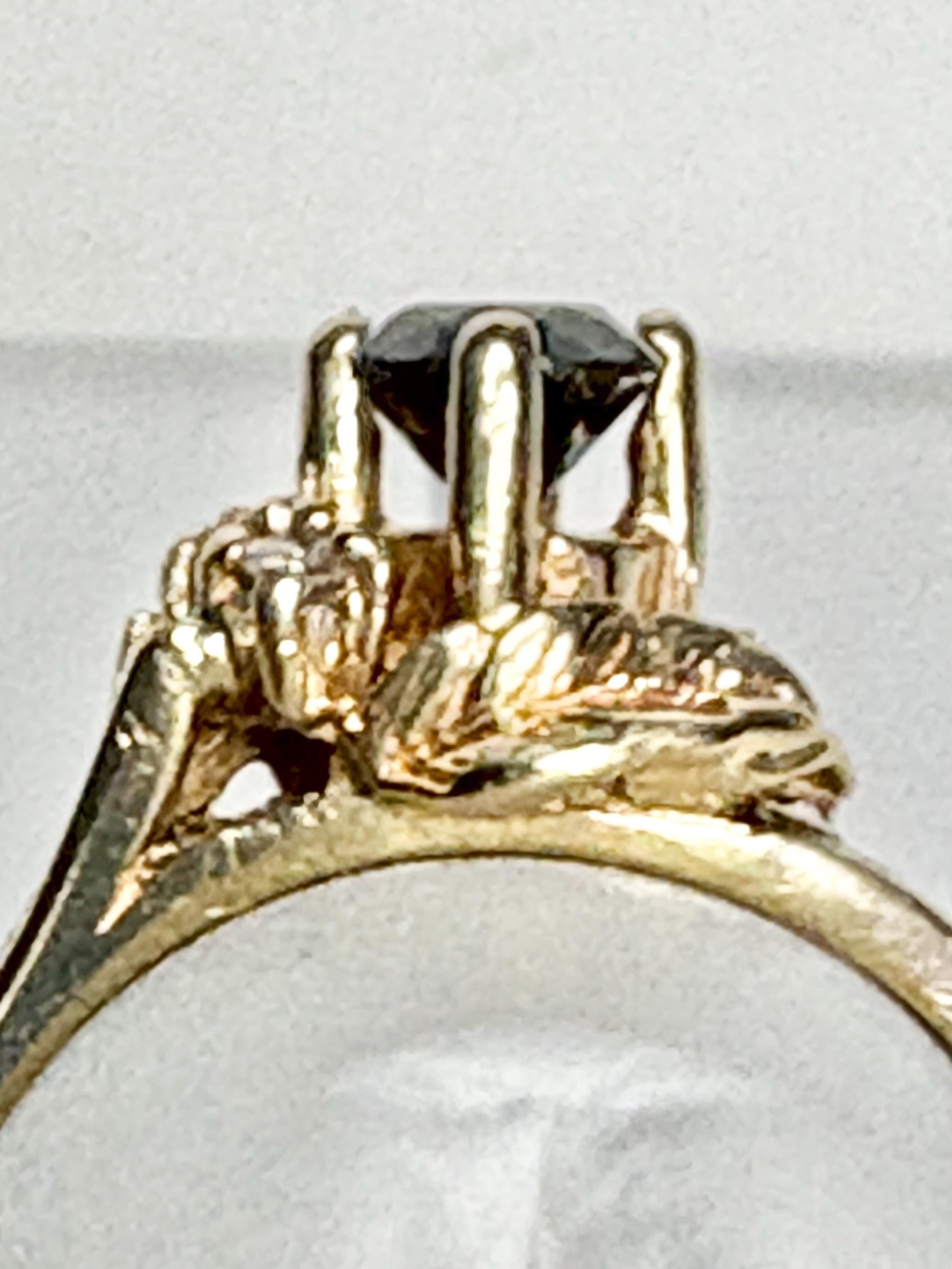A 10k yellow gold ring with a black diamond and accent diamonds.