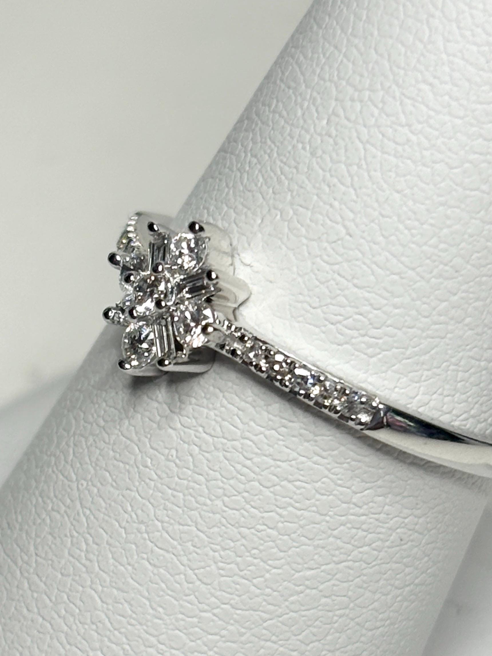 10k white gold ring with a starburst design of baguette and round diamonds.