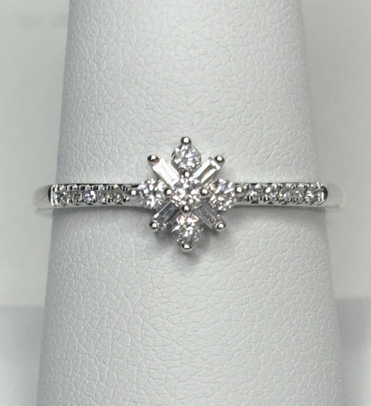 A white gold ring with a starburst design of baguette and round diamonds.