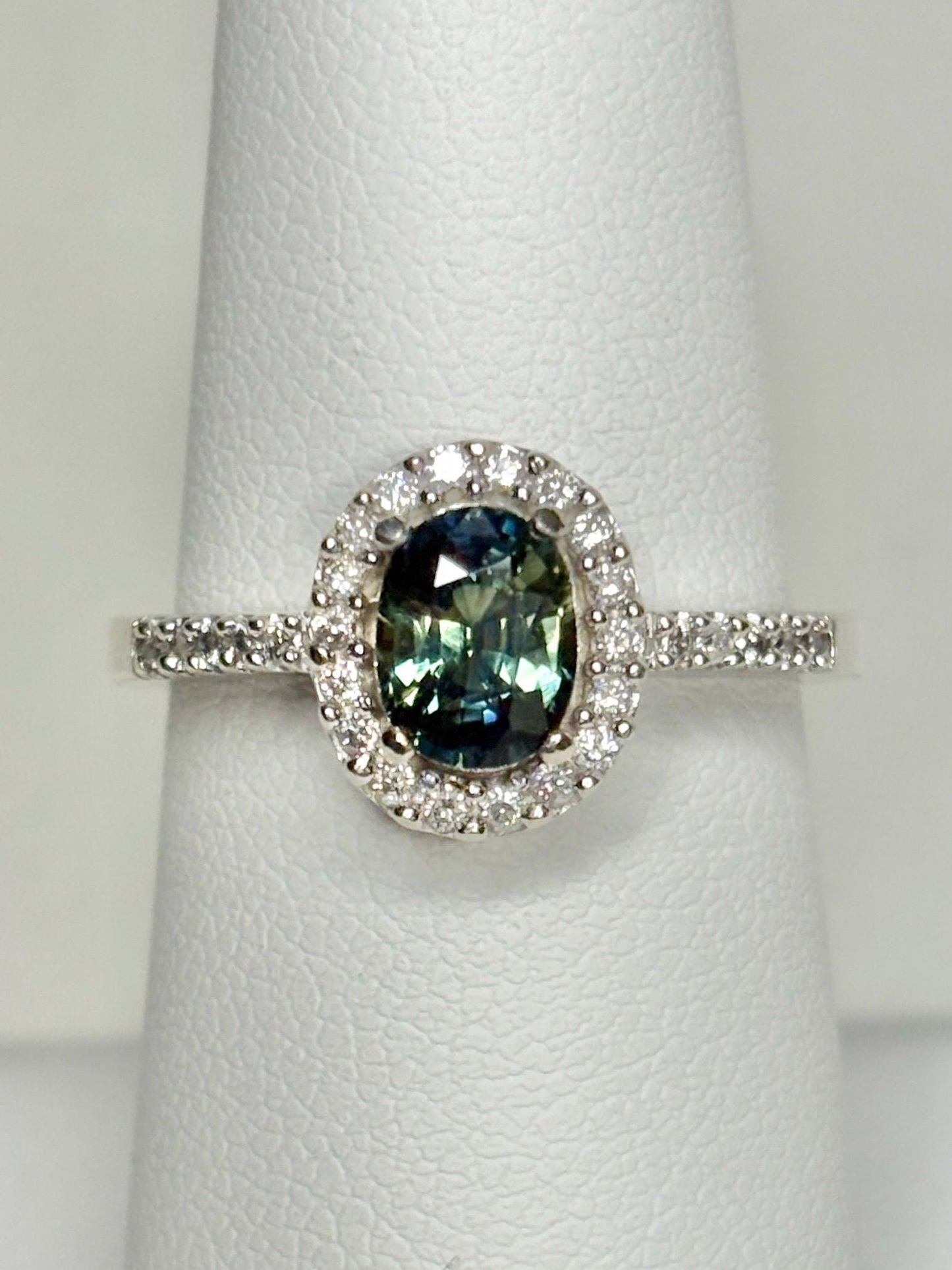 Oval bi-color sapphire and diamond halo ring in 10k white gold.
