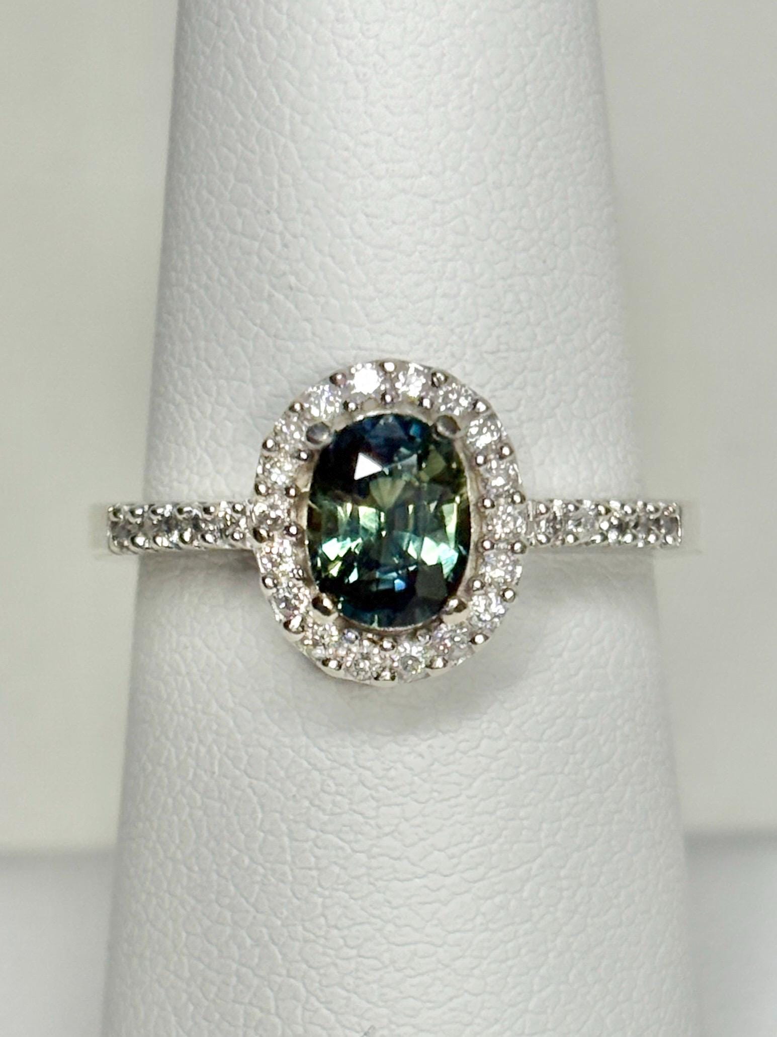 Oval bi-color sapphire and diamond halo ring in 10k white gold.