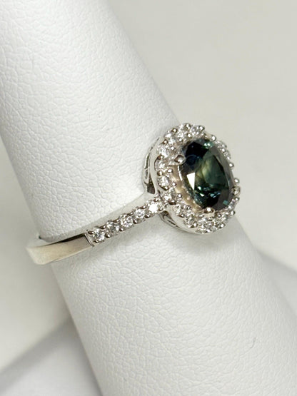 A 10k white gold ring with an oval bi-color sapphire surrounded by diamonds.