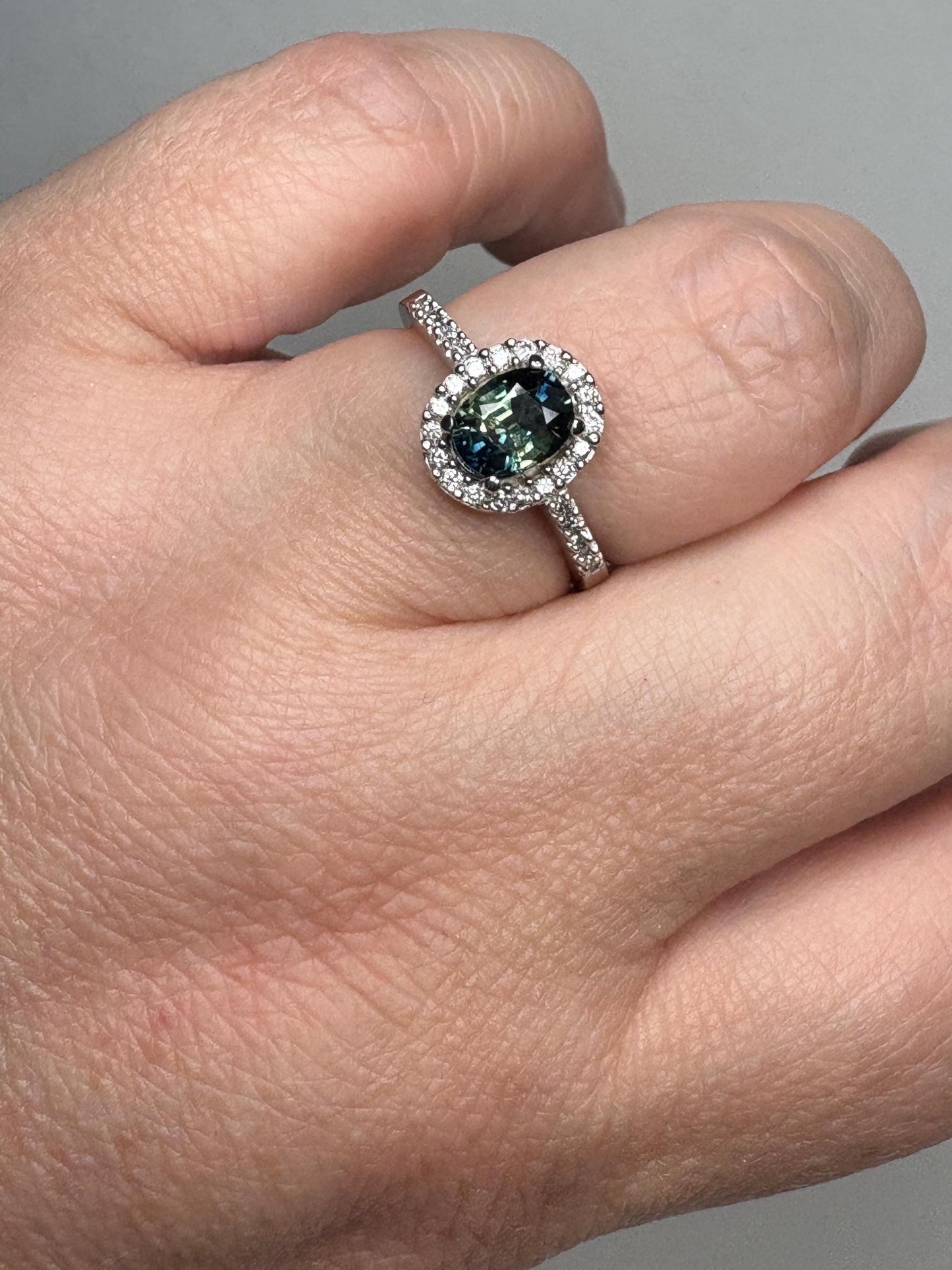 Oval bi-color sapphire and diamond halo ring in 10k white gold.