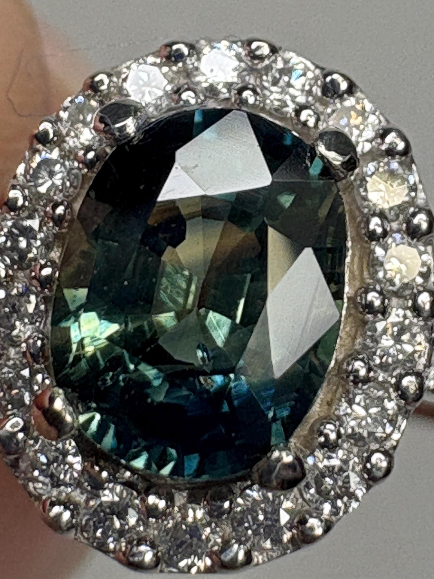 Oval bi-color sapphire and diamond halo ring in 10k white gold.