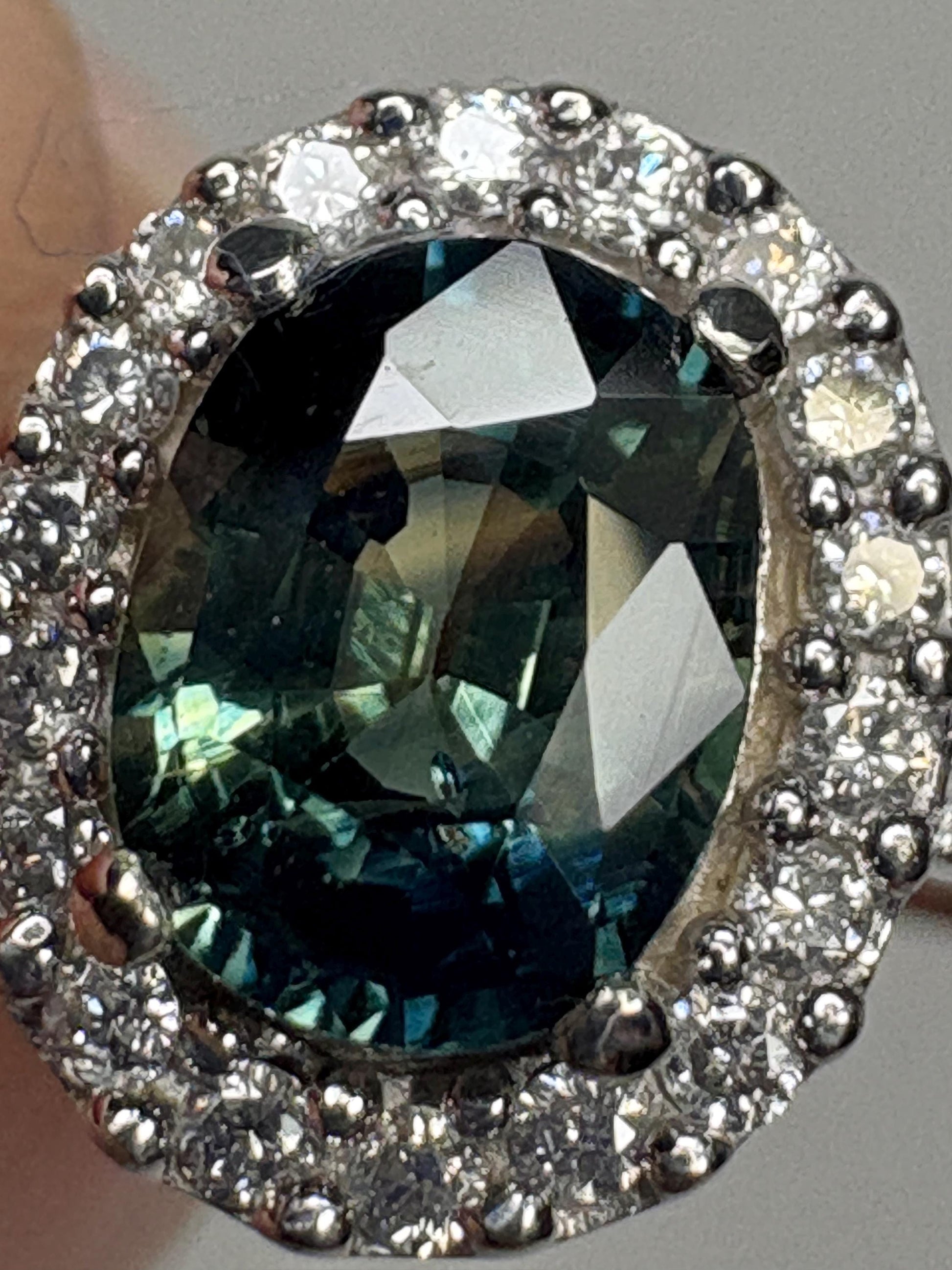 Oval bi-color sapphire and diamond halo ring in 10k white gold.