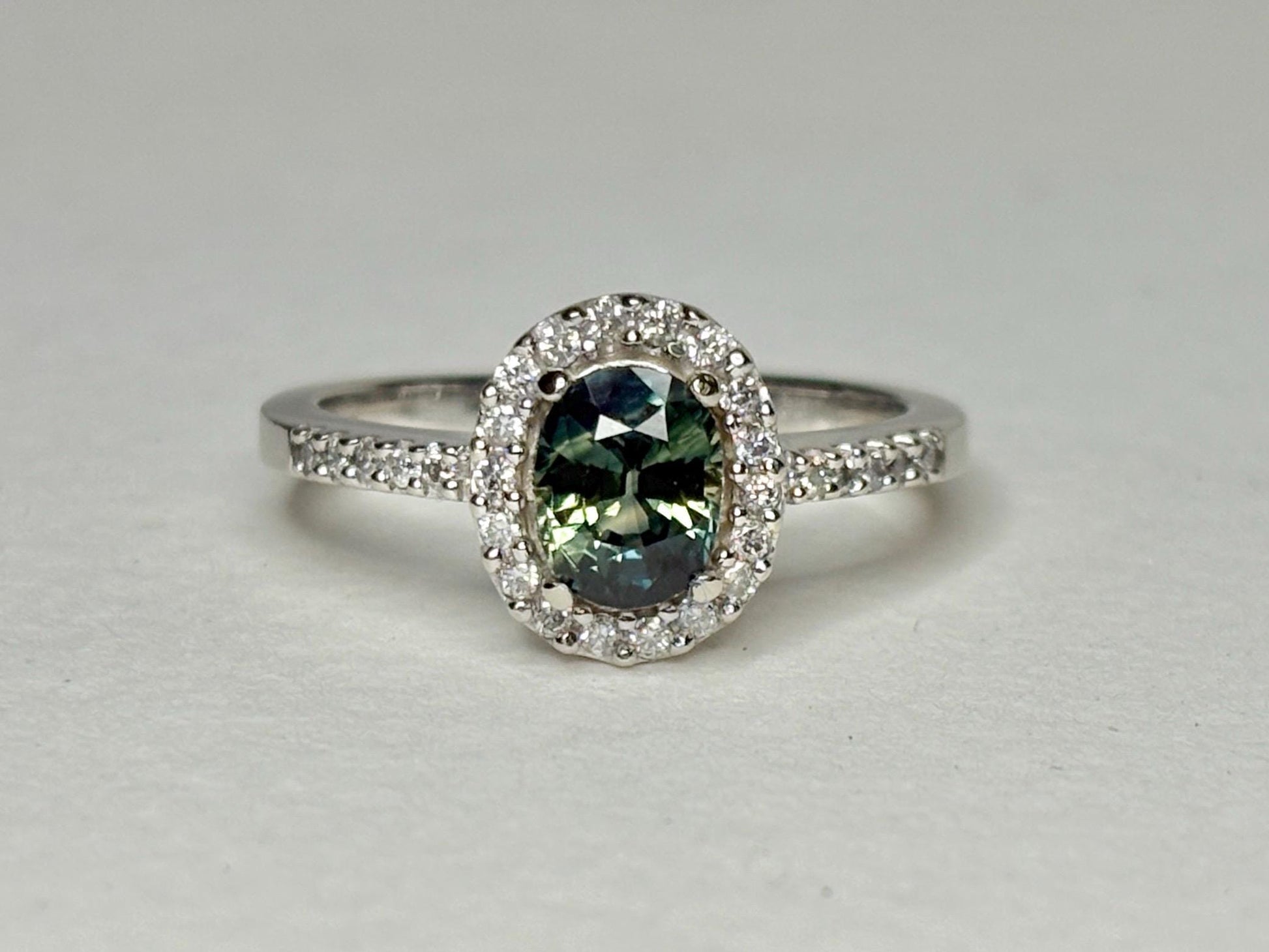 Oval bi-color sapphire and diamond halo ring in 10k white gold.