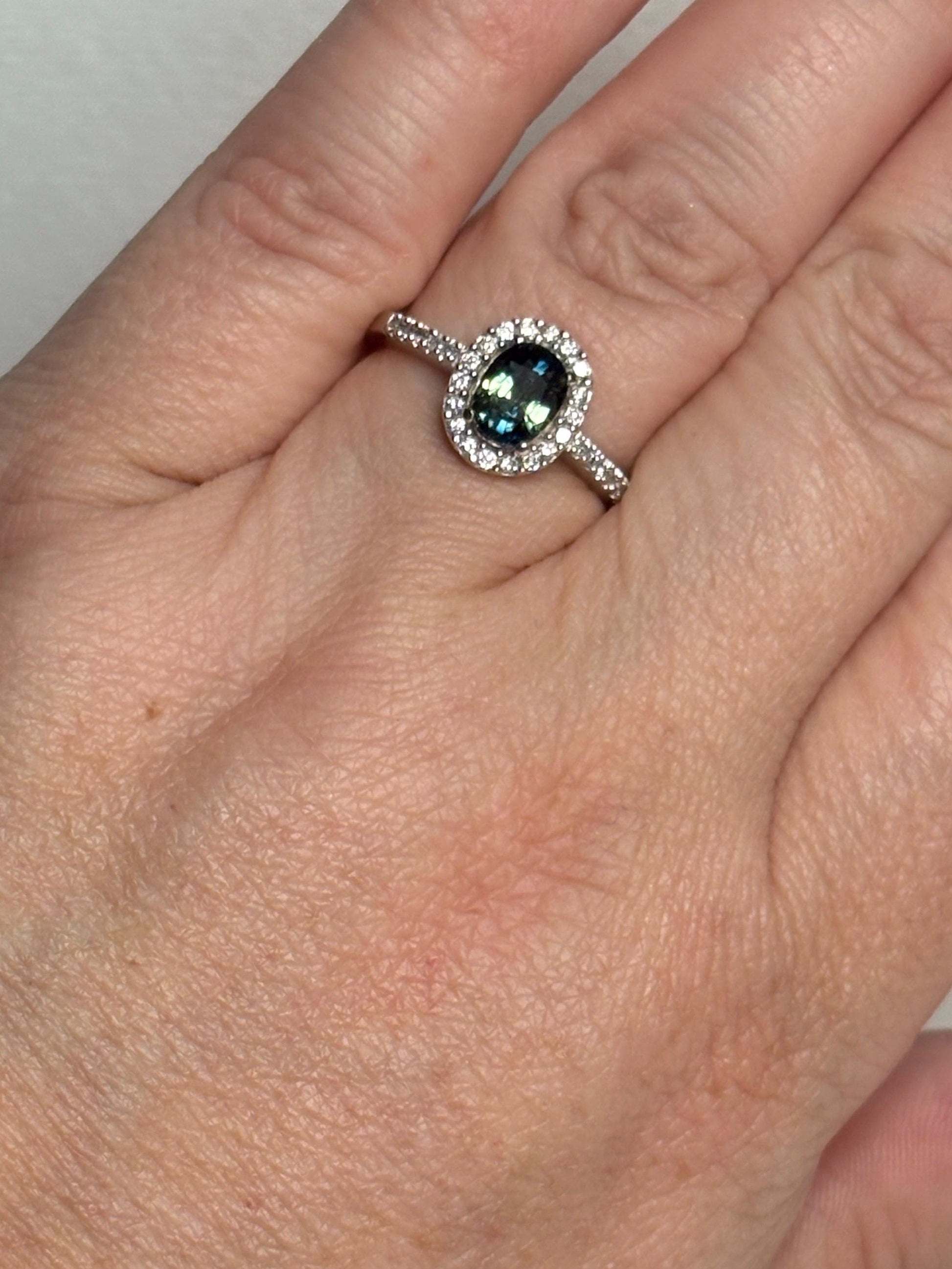 Oval bi-color sapphire and diamond halo ring in 10k white gold.