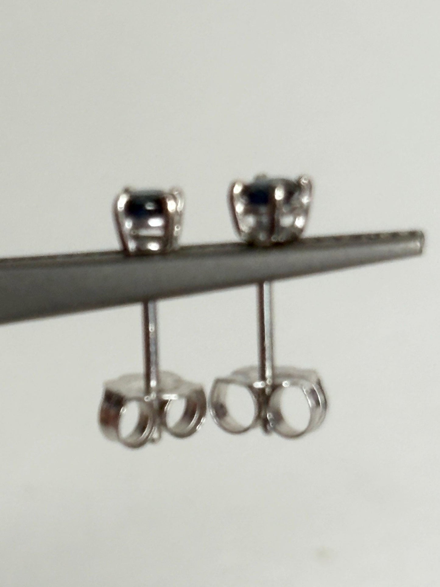 Natural dark blue sapphire stud earrings in solid 14k white gold.