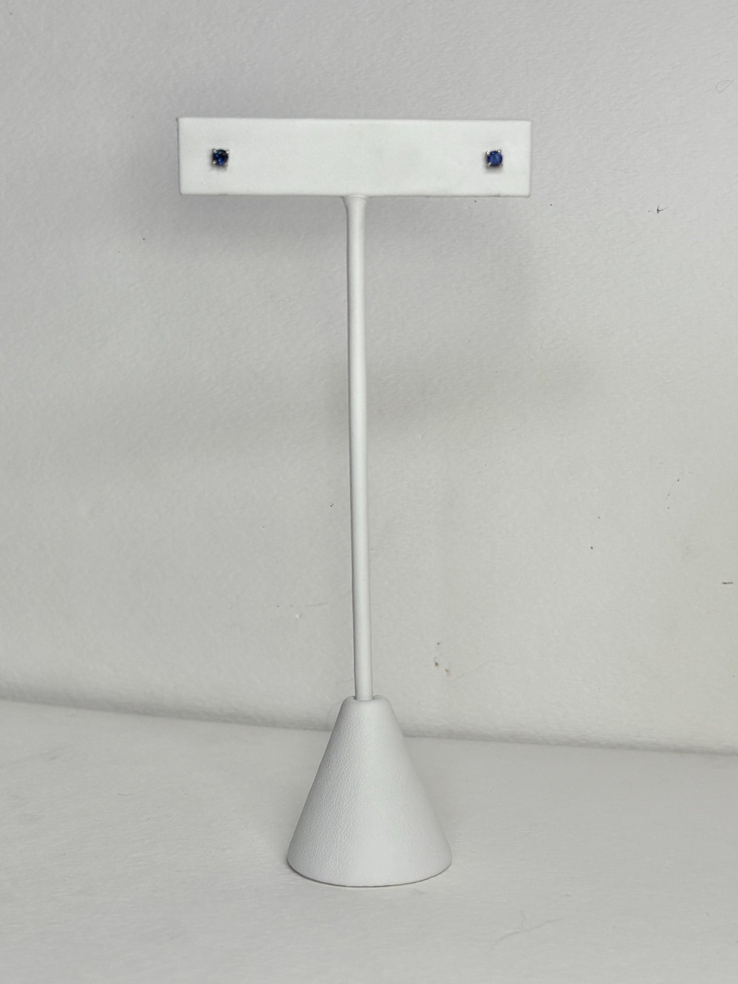 Solid 14k white gold stud earrings with small, dark blue sapphires.