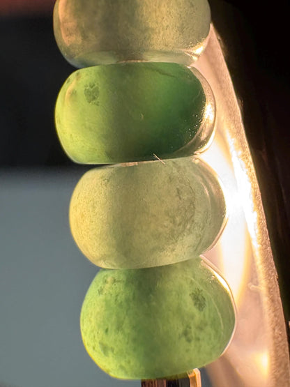 A stretch bracelet with natural jadeite jade beads and solid 14k gold beads.