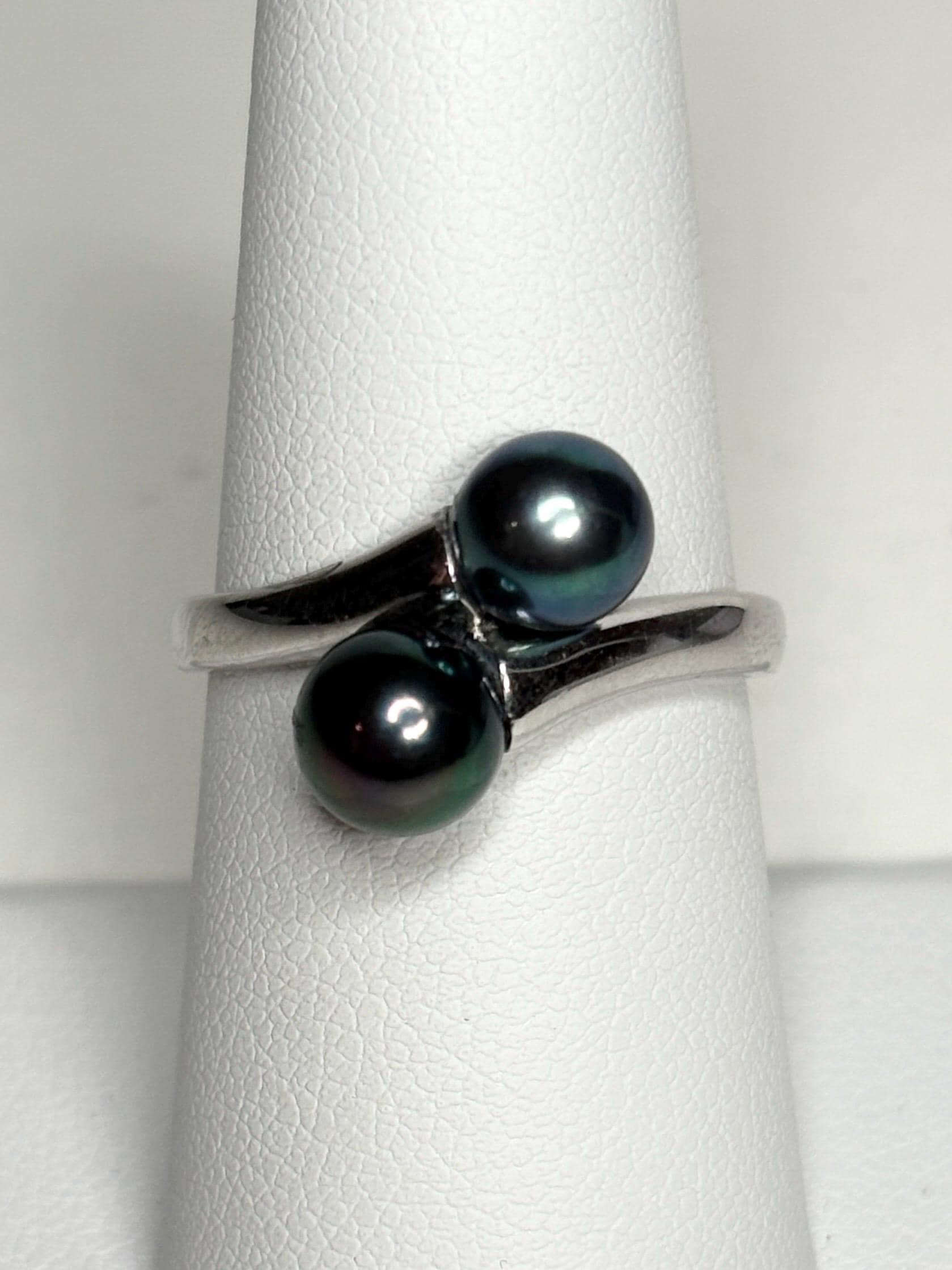 Sterling silver bypass ring with two black Akoya pearls.