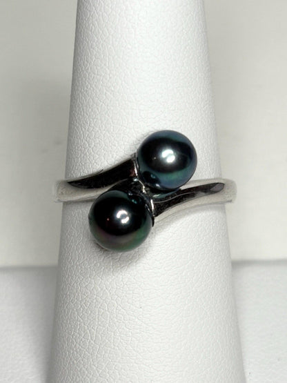 Sterling silver bypass ring with two black Akoya pearls.