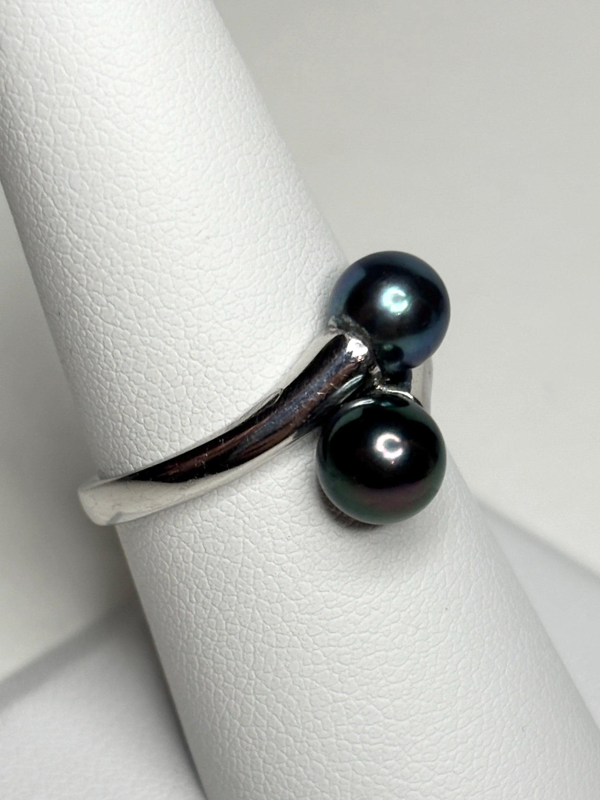 Sterling silver bypass ring with two black Akoya pearls.