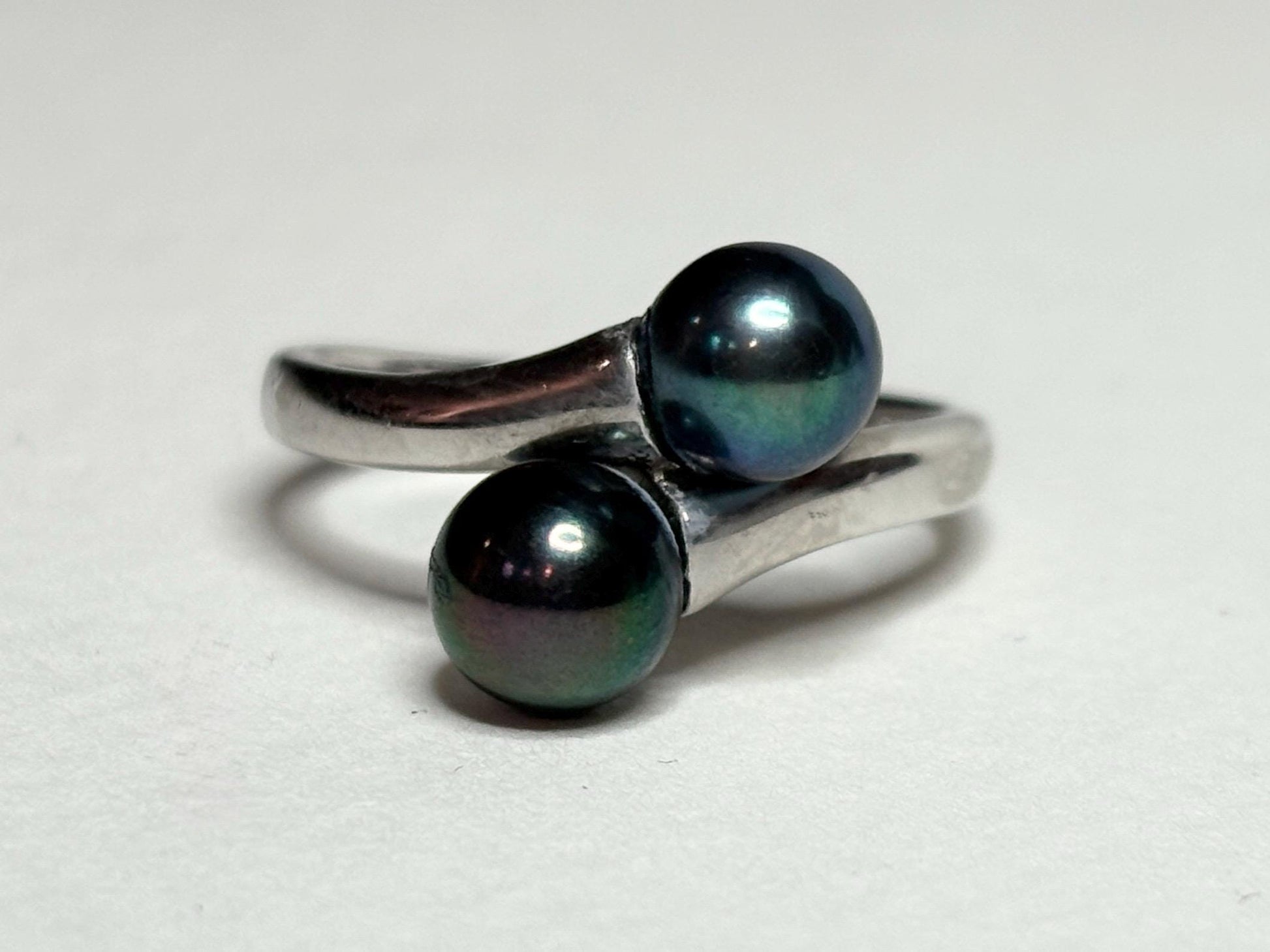 Sterling silver bypass ring with two black Akoya pearls.