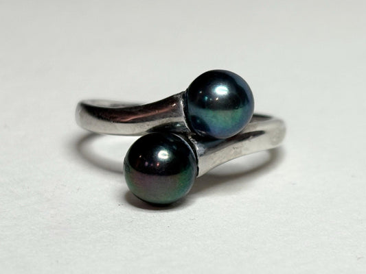 Sterling silver bypass ring with two black Akoya pearls.