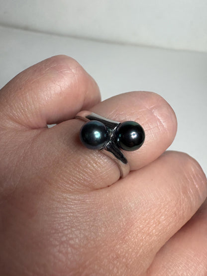 Sterling silver bypass ring with two black Akoya pearls.