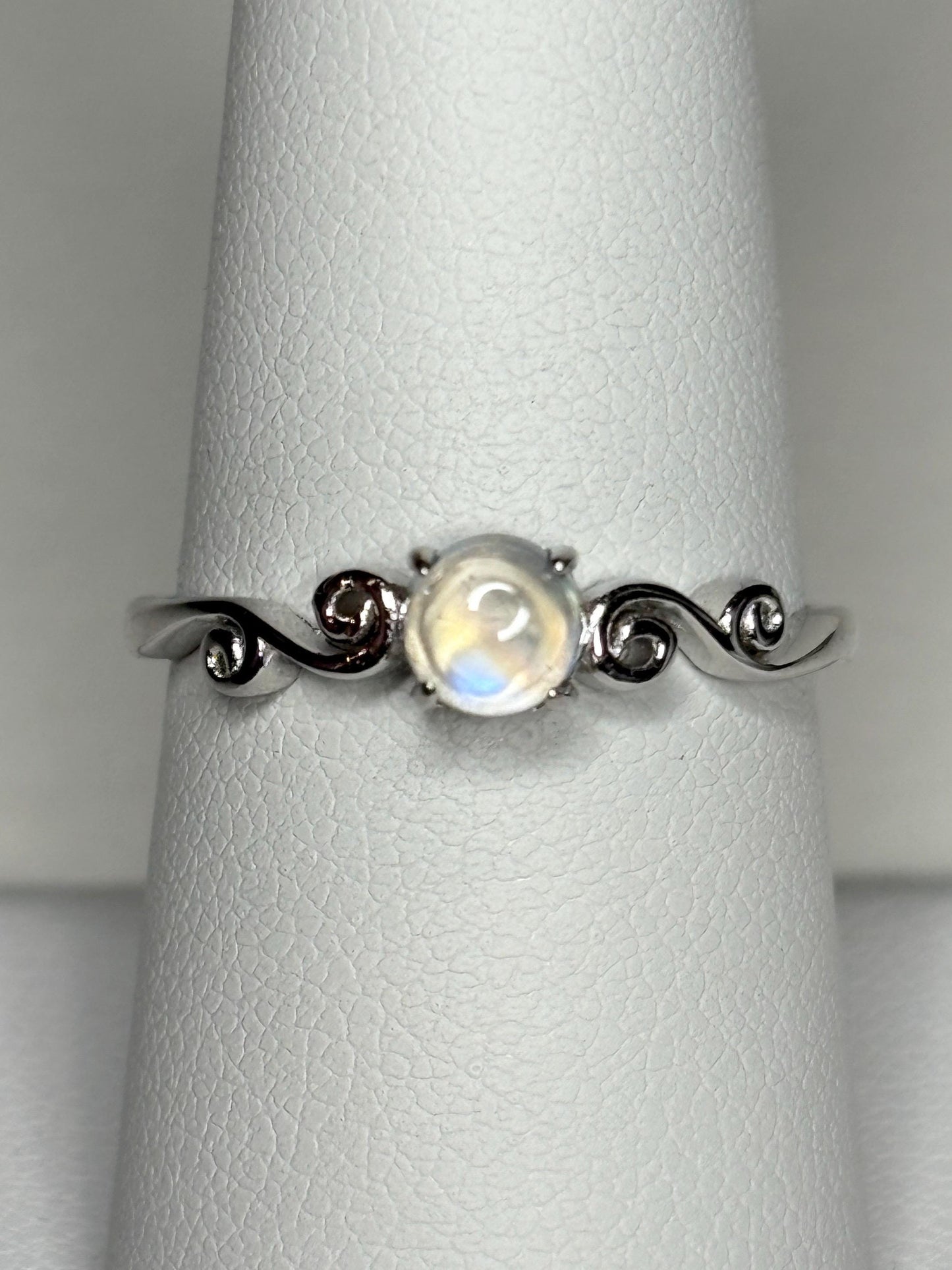 Sterling silver ring with a rainbow moonstone cabochon and swirl details.