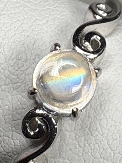 Sterling silver ring with a rainbow moonstone cabochon and swirl design.