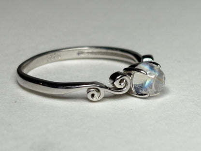 Sterling silver ring with a rainbow moonstone cabochon and swirl details.