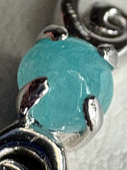 Sterling silver ring with a blue tourmaline cabochon and swirl design.