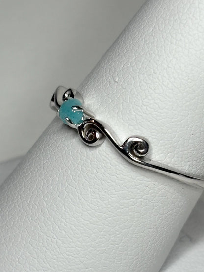 Sterling silver ring with a blue Paraiba tourmaline and swirl design.