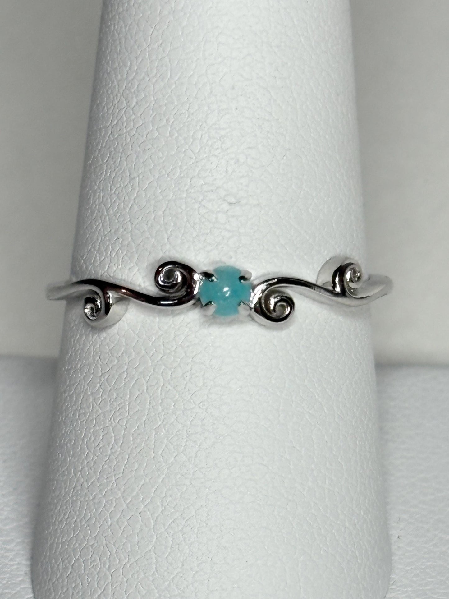 Sterling silver ring with a blue tourmaline and swirl design.