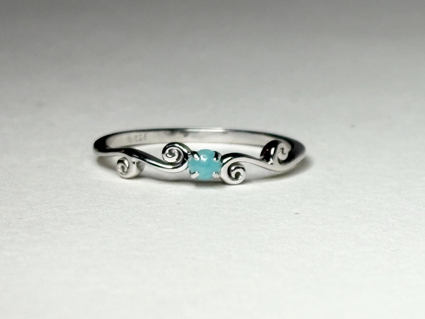 Sterling silver ring with a blue tourmaline and swirl design.
