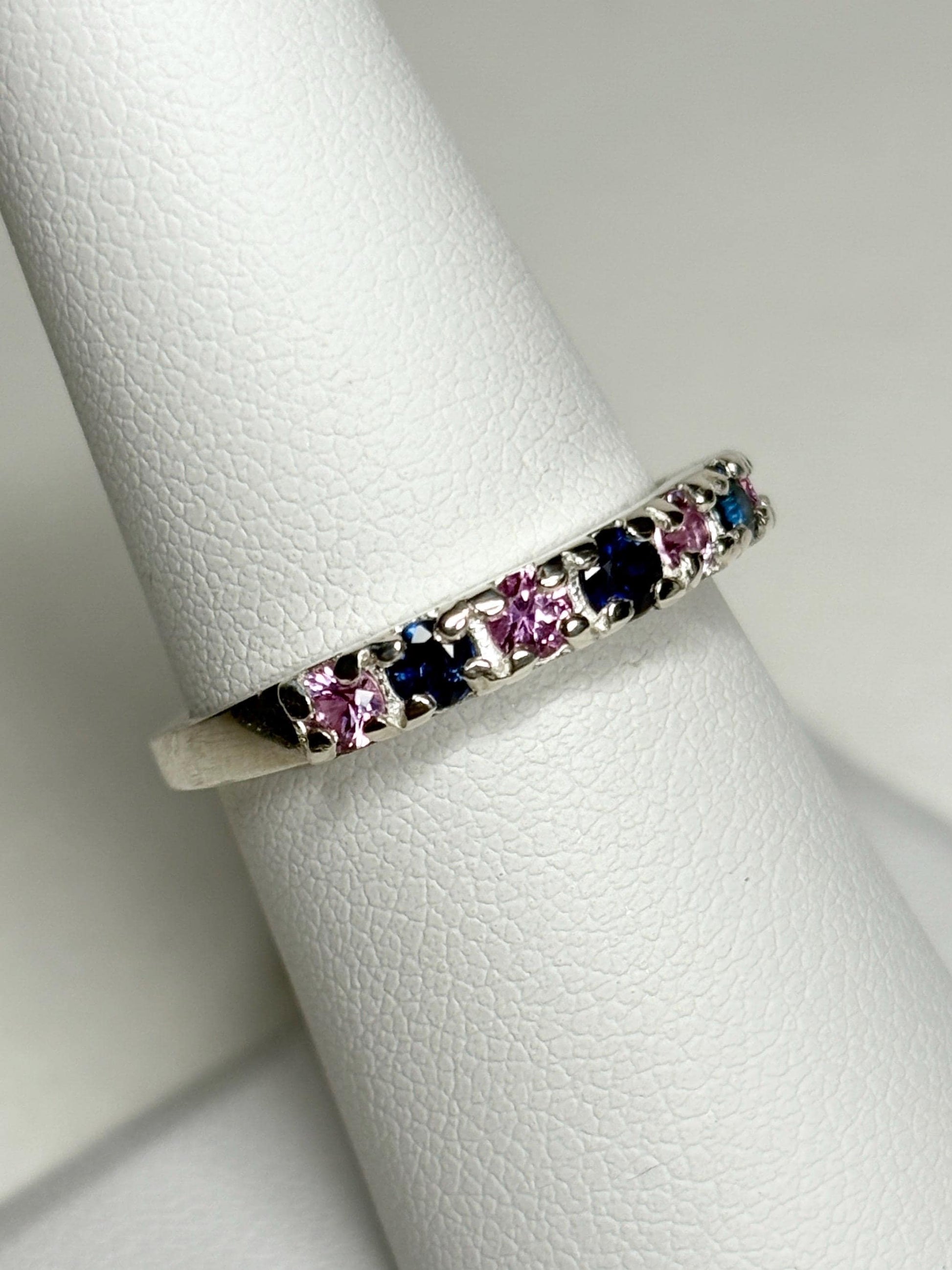 Sterling silver band ring with alternating blue and pink sapphires.