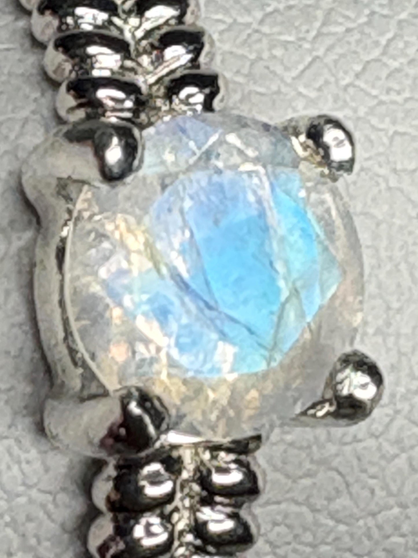 Sterling silver ring with a round rainbow moonstone and double rope band.