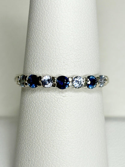 Sterling silver band ring with alternating blue and light blue sapphires.