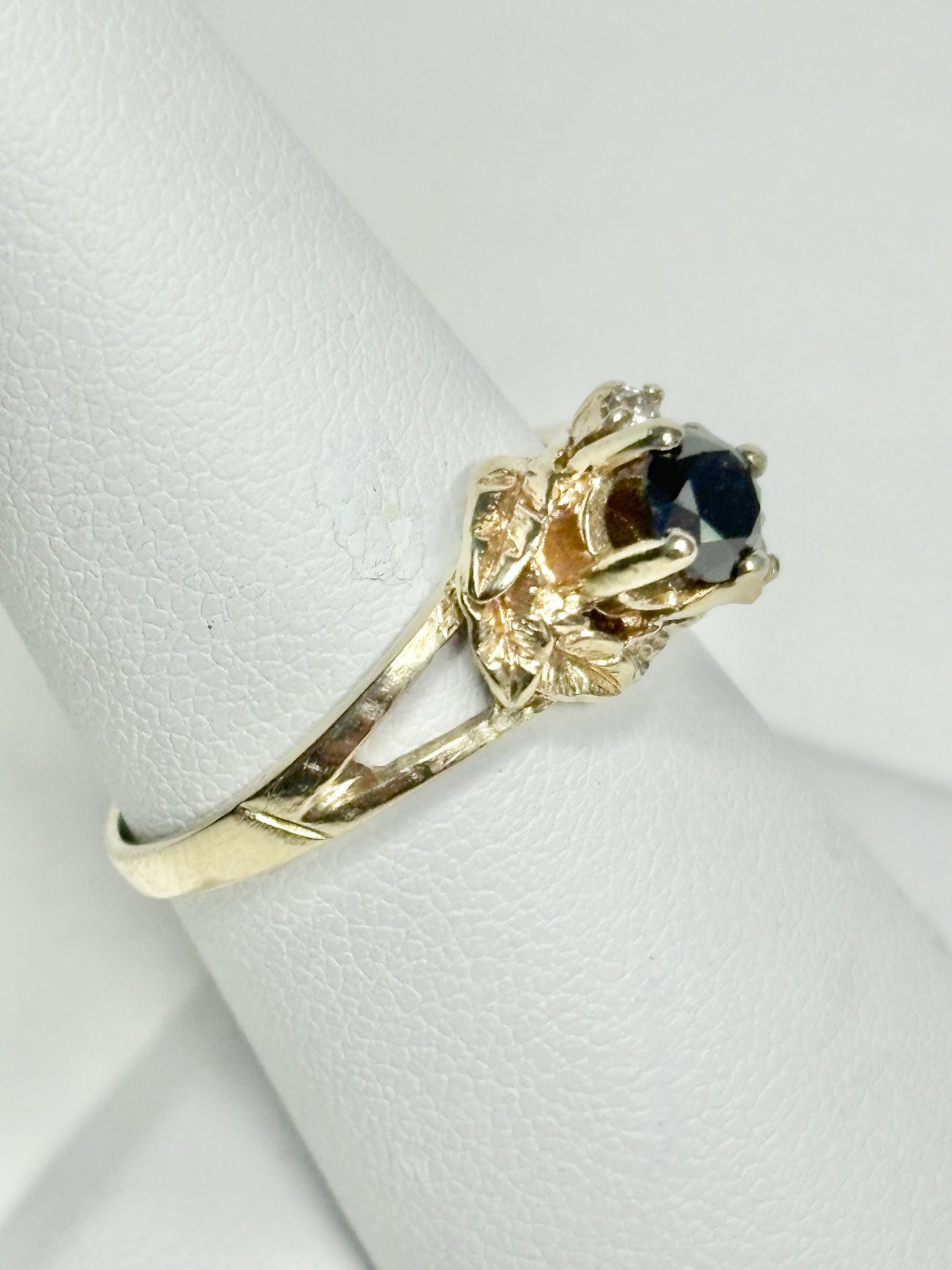 A 10k yellow gold ring with a black diamond and accent diamonds.