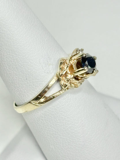 A 10k yellow gold ring with a black diamond and accent diamonds.