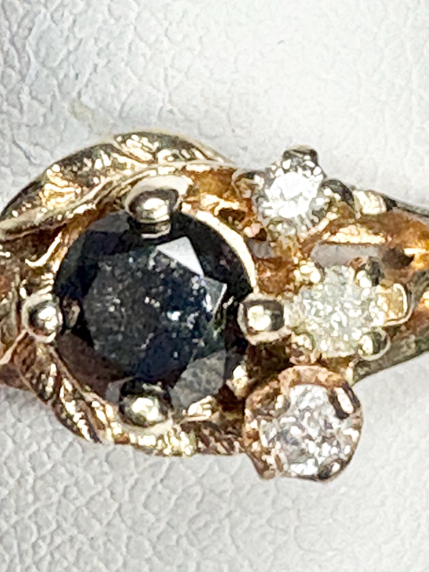 10k gold ring with a black diamond center and surrounding white diamonds.