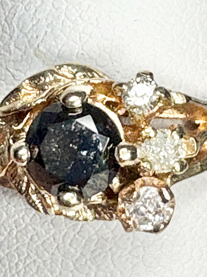 10k gold ring with a black diamond center and surrounding white diamonds.