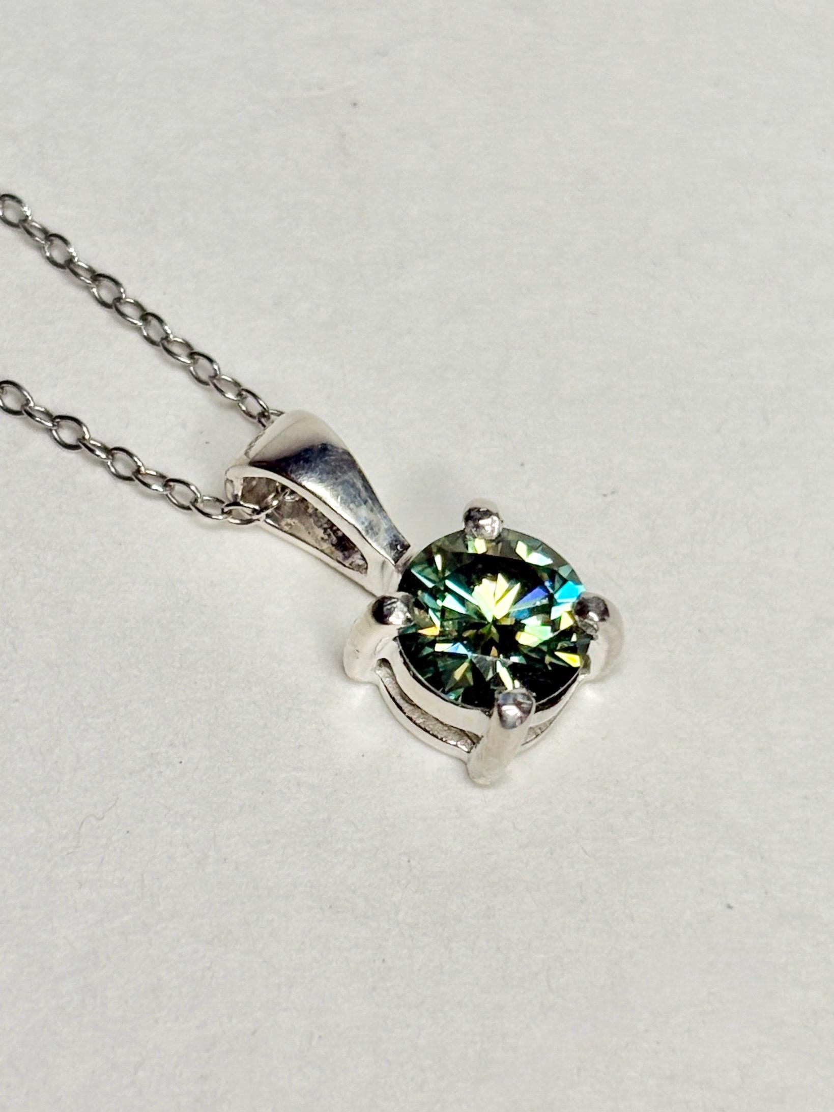 Teal-green moissanite solitaire pendant necklace in sterling silver.