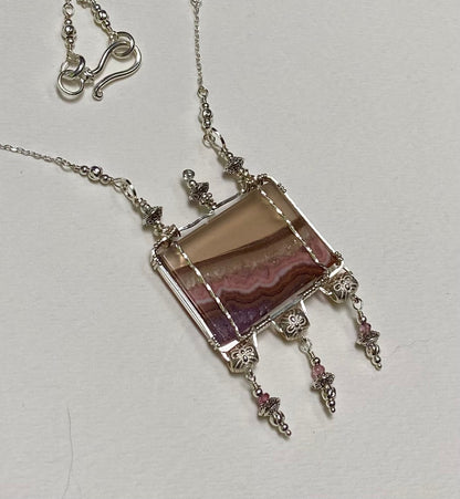 Sterling silver necklace with a rectangular agate and amethyst pendant and pink spinel accents.