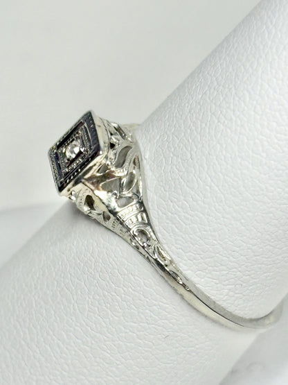 Antique Art Deco 18k gold ring with a diamond chip and filigree details.