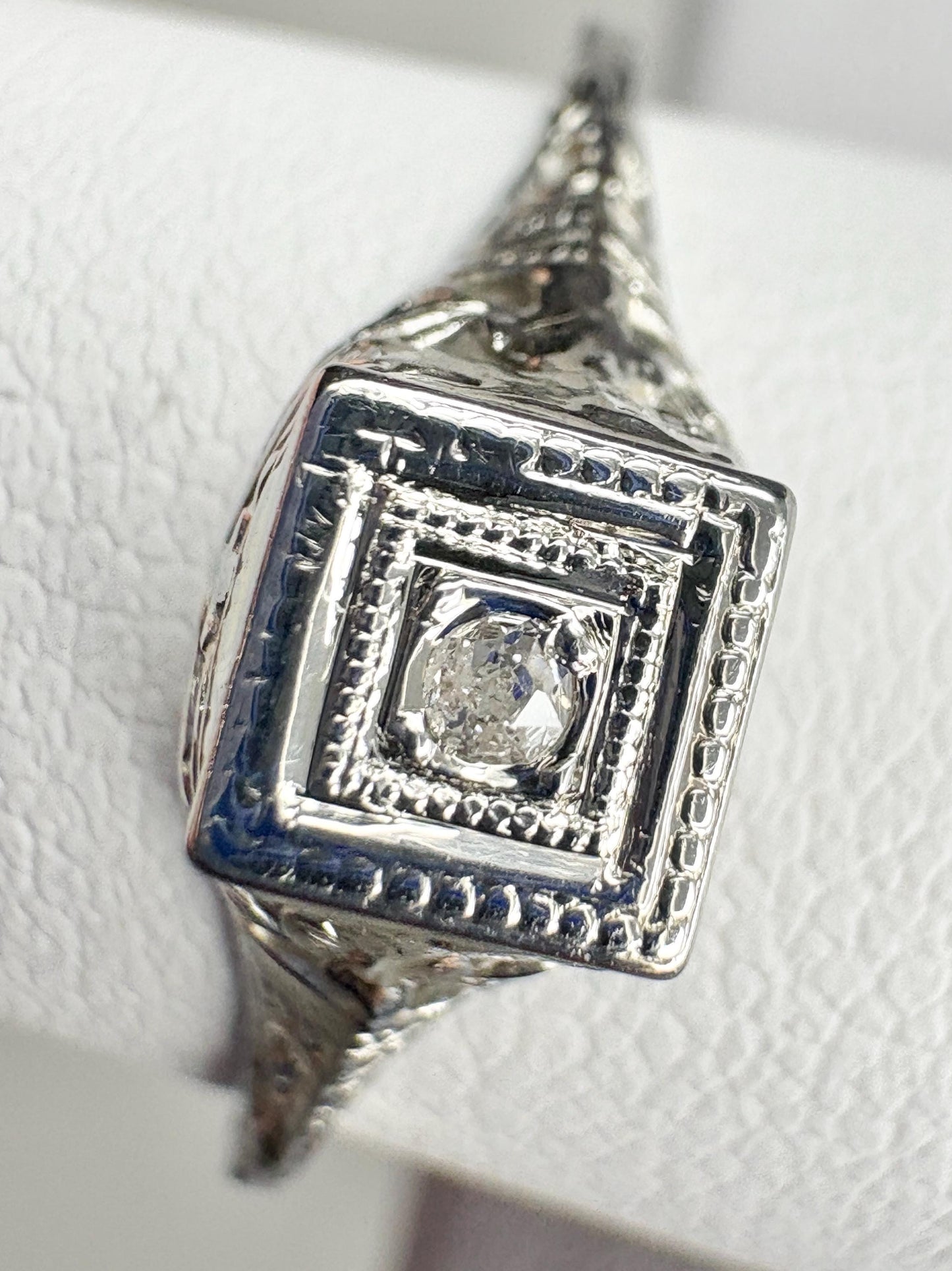 Art Deco 18k gold ring with a small old mine cut diamond and filigree details.