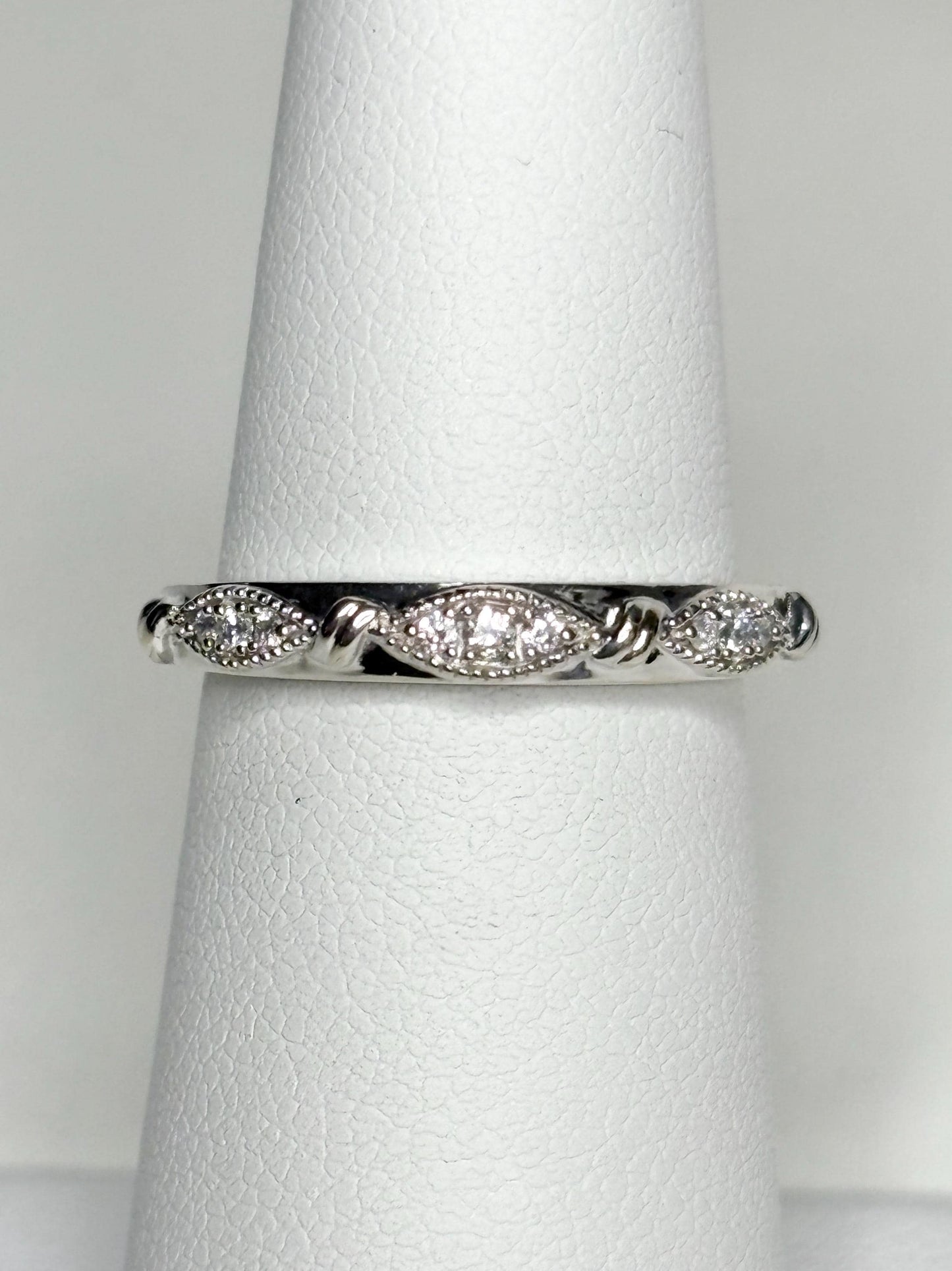 A 10k white gold band ring with diamonds and milgrain detail.