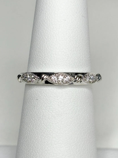 A 10k white gold band ring with diamonds and milgrain detail.