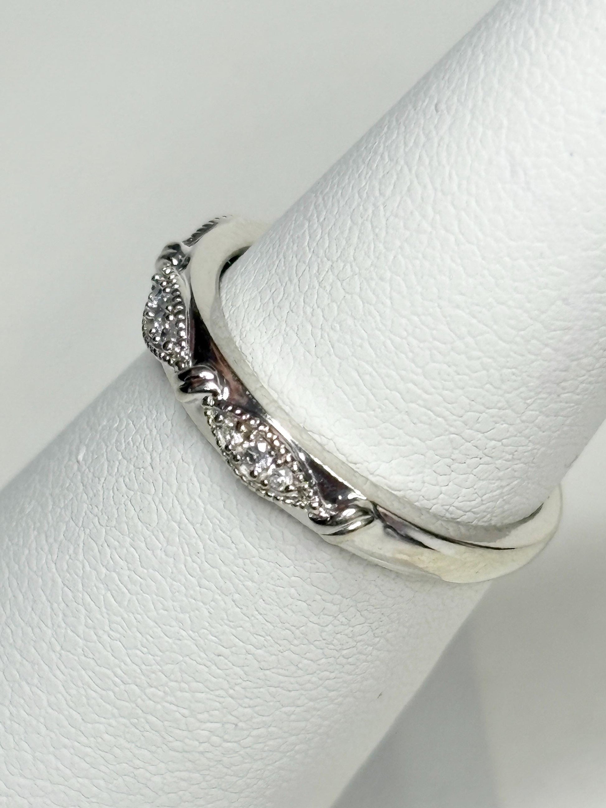 Stackable 10k white gold band ring with diamonds and milgrain detail.