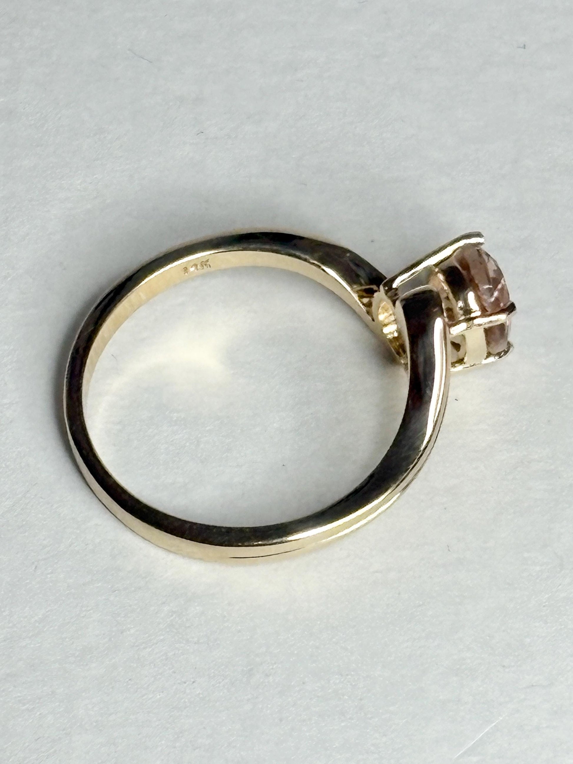A 14k gold bypass ring with a light peach Oregon sunstone.