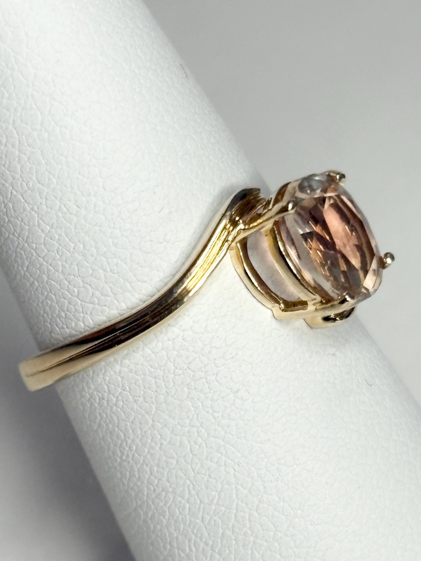 A 14k gold bypass ring with a light peach Oregon sunstone.