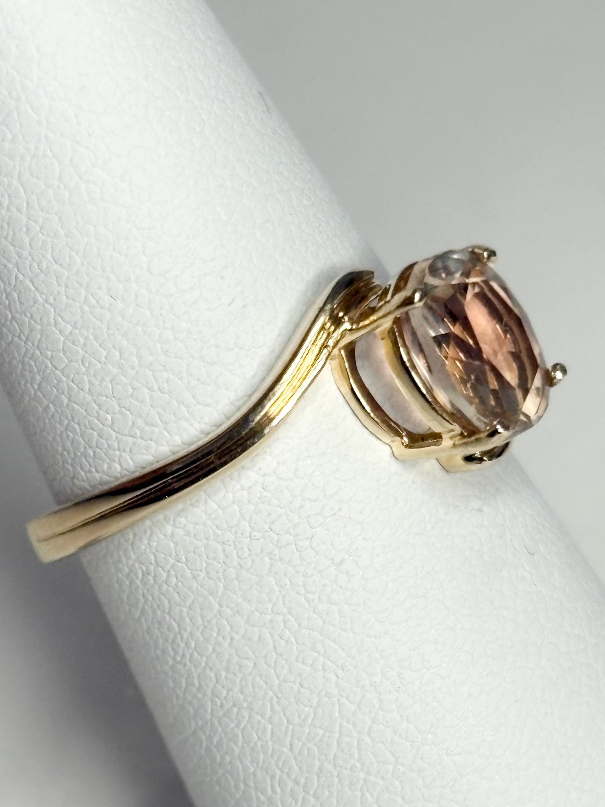 A 14k gold bypass ring with a light peach Oregon sunstone.