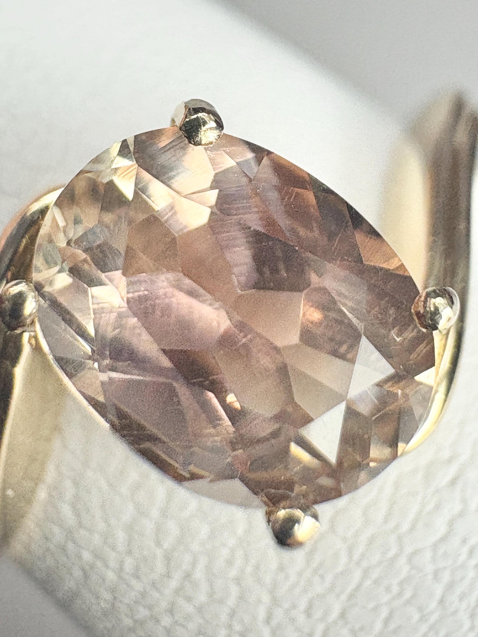 A 14k gold bypass ring featuring a light peach oval Oregon sunstone.