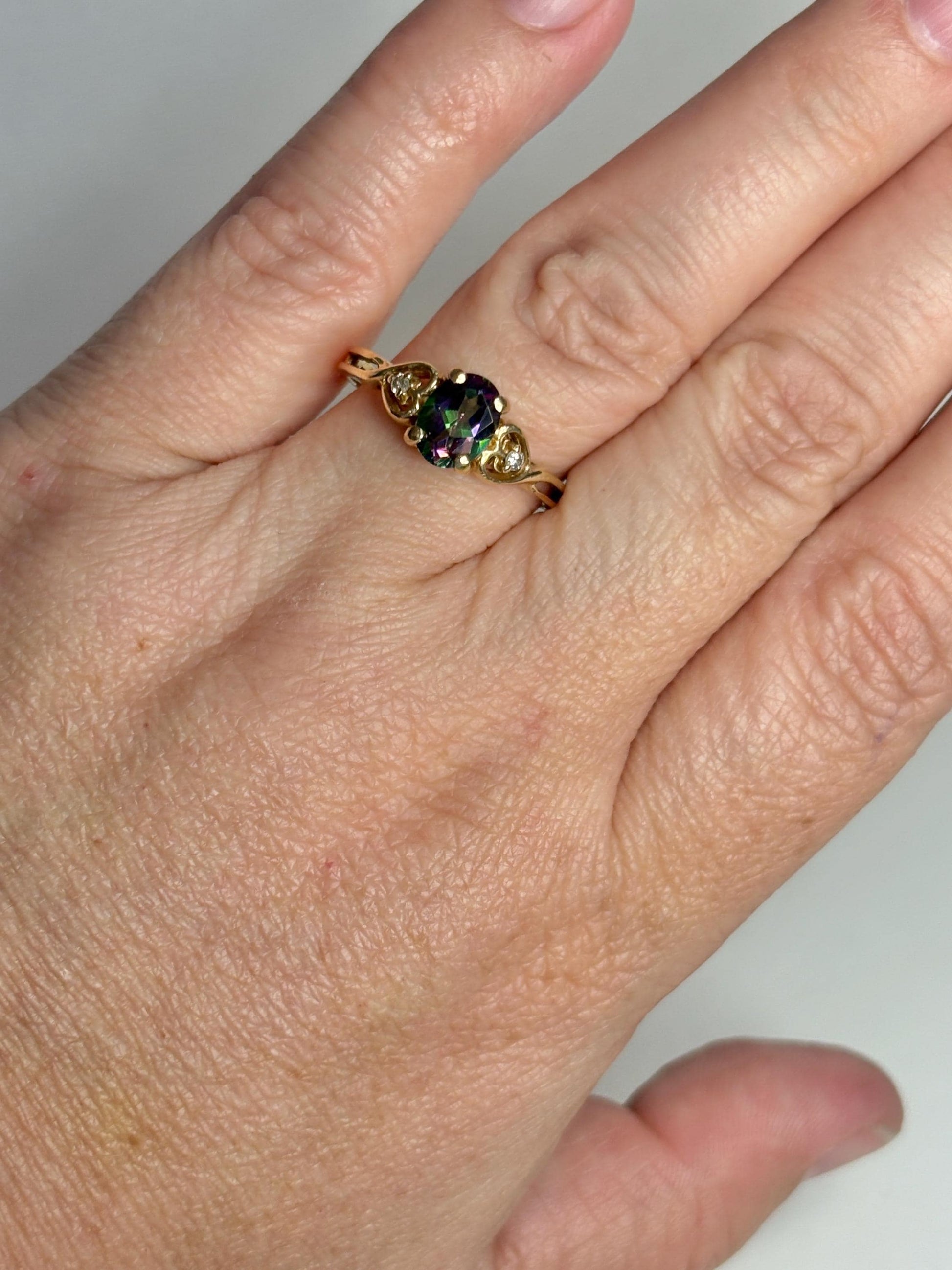 A 10k gold ring with a mystic topaz and two diamonds.