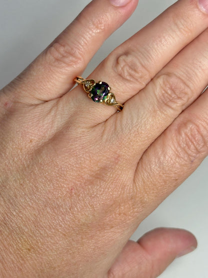 A 10k gold ring with a mystic topaz and two diamonds.