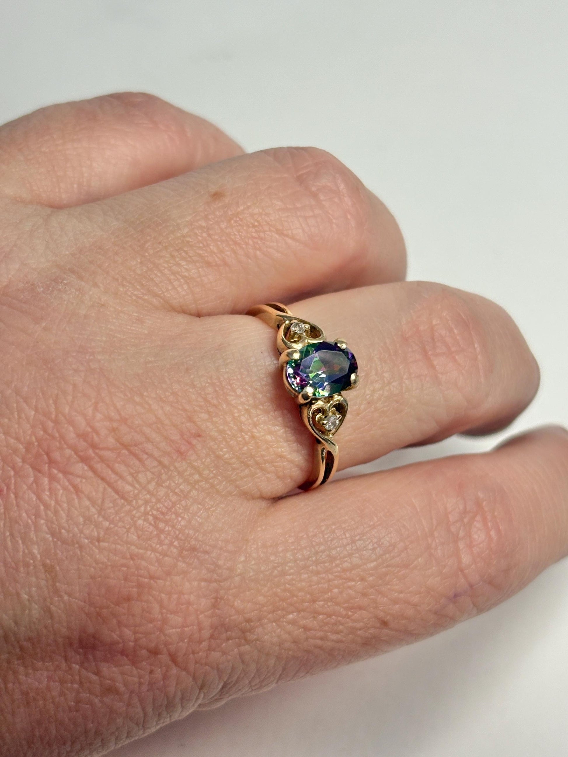 A 10k yellow gold ring with a mystic topaz and two diamonds.