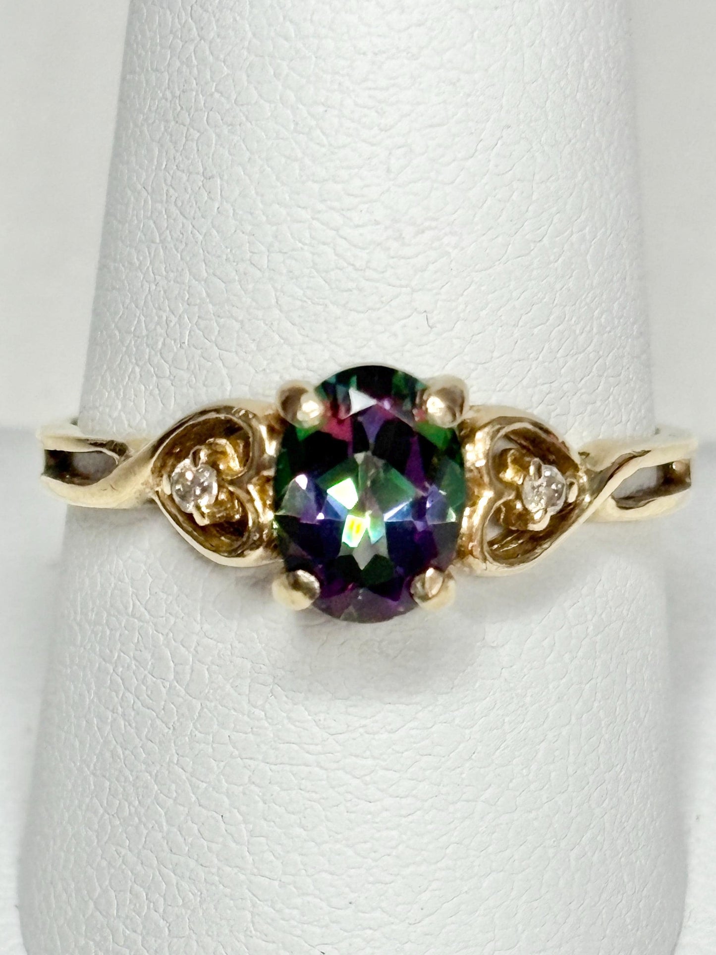 A 10k yellow gold ring with a mystic topaz center stone and two diamonds.