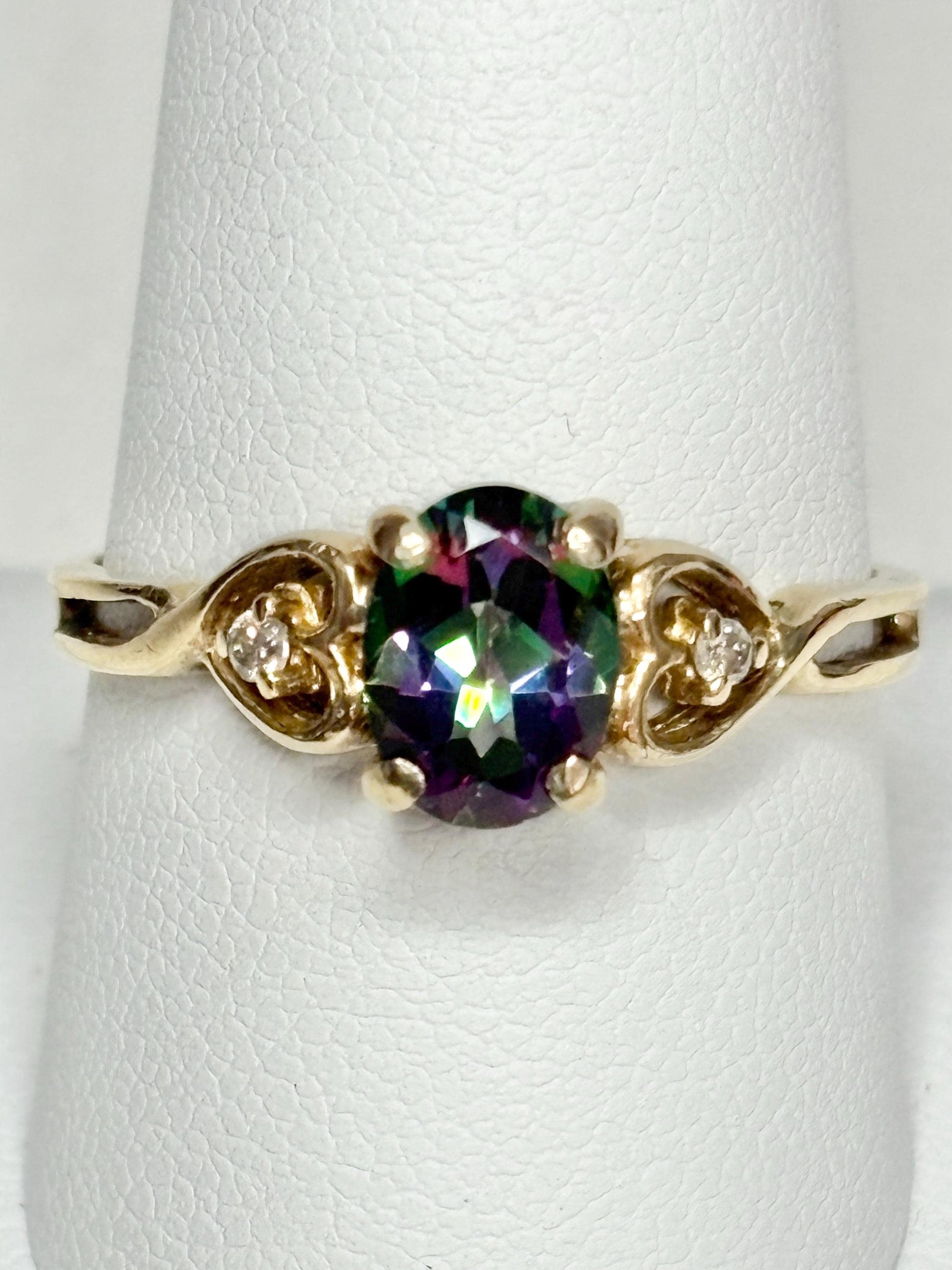 A 10k yellow gold ring with a mystic topaz center stone and two diamonds.